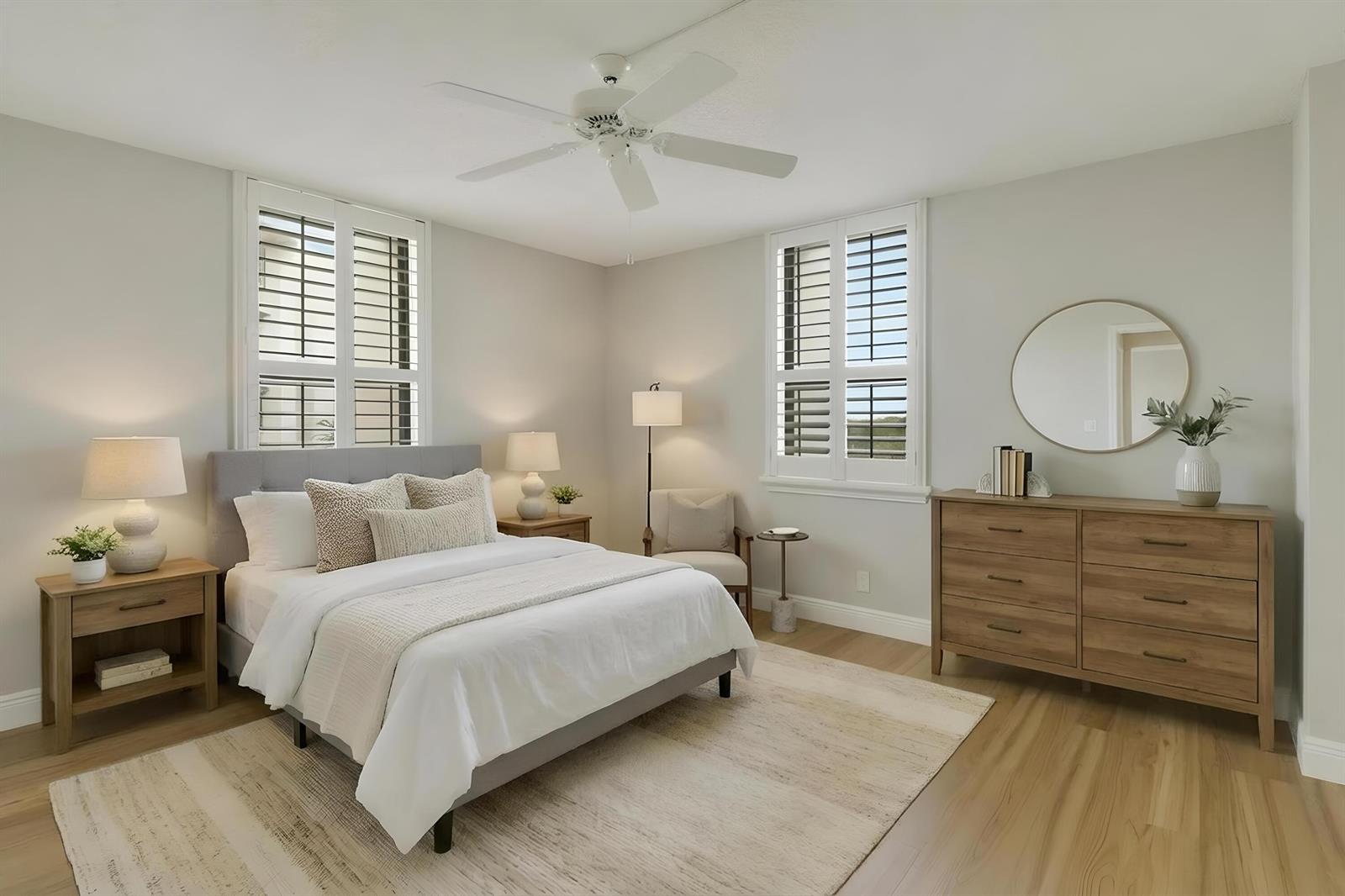 A bedroom features a gray upholstered bed, wooden nightstands, a matching dresser, and plantation shutters — 1748 Jupiter Cove Drive # 417, Jupiter FL 33469, JUPITER, FL