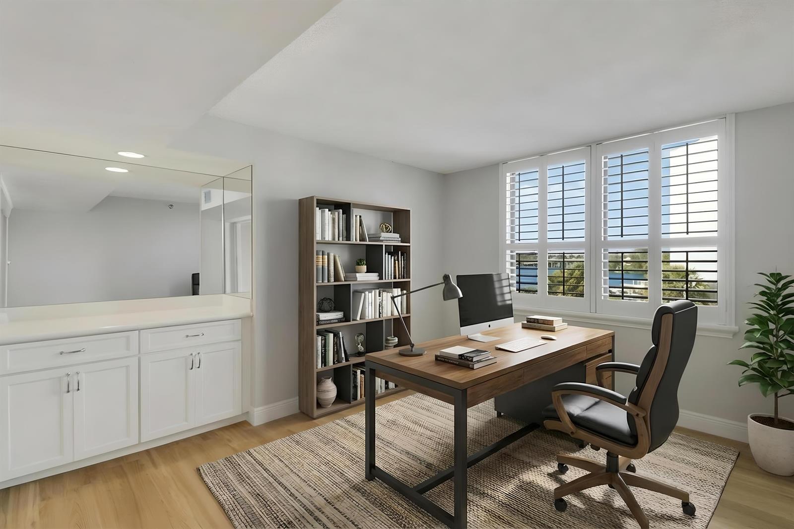 A home office features a wooden desk, a bookshelf, white cabinetry, and windows with shutters — 1748 Jupiter Cove Drive # 417, Jupiter FL 33469, JUPITER, FL