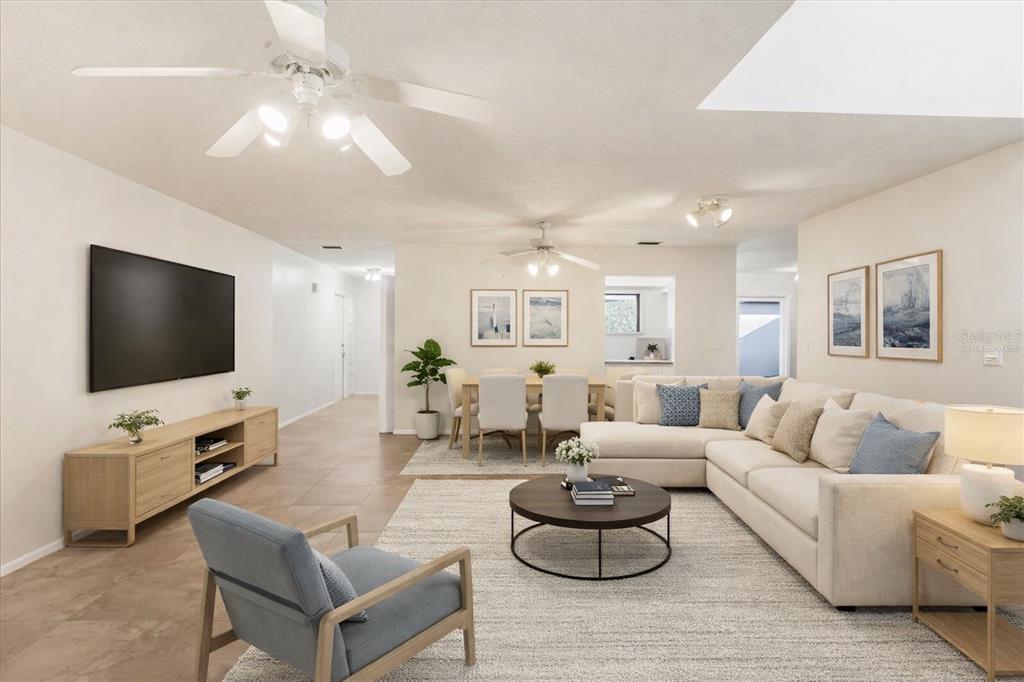 A bright, open-concept living and dining area features light tile floors and neutral furniture — 3820 GLEN OAKS MANOR DRIVE, SARASOTA, FL