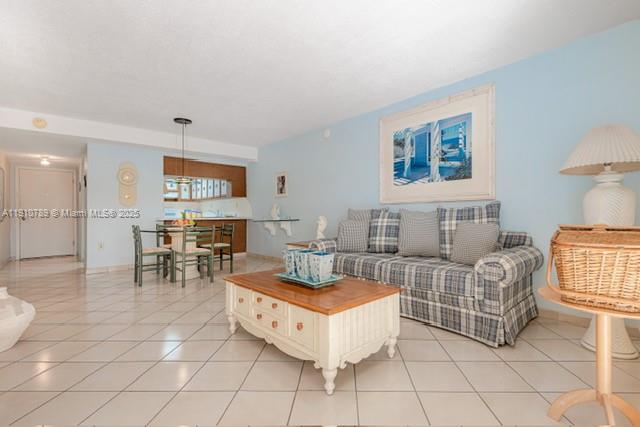A living room with light blue walls, tile flooring, a plaid sofa, and a coffee table — 1890 W 56th St # 1423, Hialeah FL 33012, HIALEAH, FL