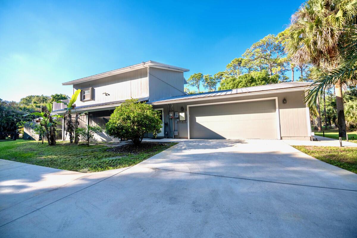 A two-story house with gray siding, a metal roof, and an attached two-car garage — 16887 97th Way N, Jupiter FL 33478, JUPITER, FL
