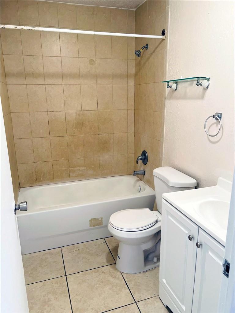 A bathroom features a tiled tub surround, a white toilet, and a white vanity cabinet — 400 NW 65th Avenue # 209, Margate FL 33063, MARGATE, FL