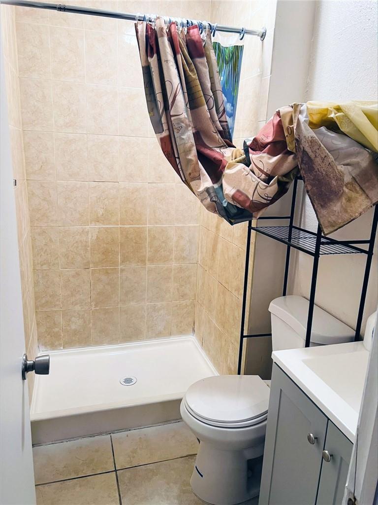 A small bathroom featuring a tiled shower stall, a toilet, and a vanity cabinet — 400 NW 65th Avenue # 209, Margate FL 33063, MARGATE, FL