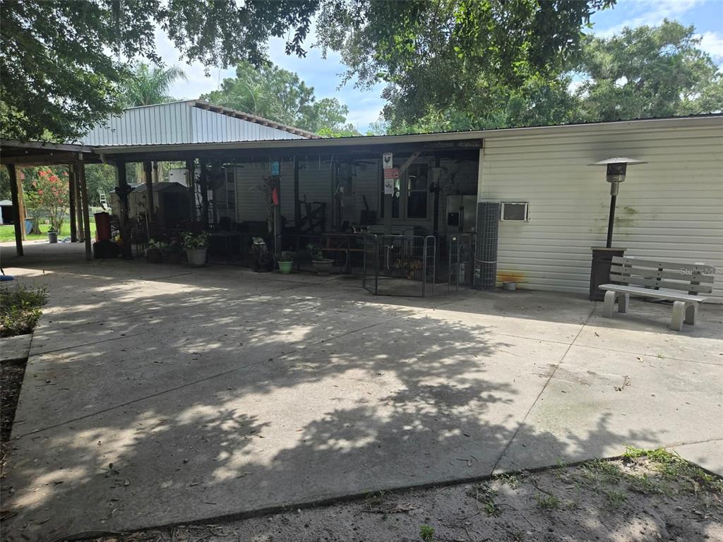 A large concrete patio sits in front of a house with a covered porch area — 3845 CHAPLAIN ROAD, ST CLOUD, FL