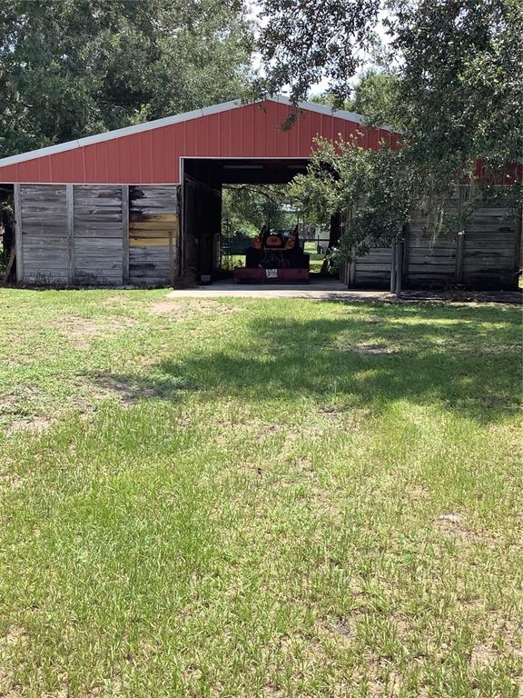 A red-roofed barn with weathered wooden siding stands in a grassy field — 3845 CHAPLAIN ROAD, ST CLOUD, FL