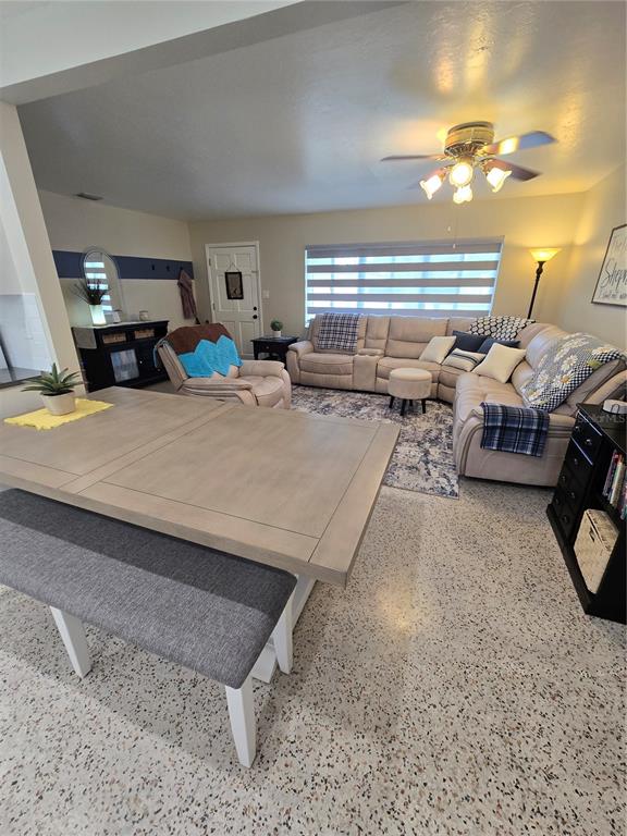 A living room features a sectional sofa, a dining table with a bench, and terrazzo flooring — 3134 IRVING STREET, SARASOTA, FL