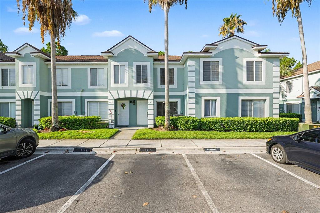 A two-story teal townhouse exterior with white trim, palm trees, and a parking lot — 2125 FLUORSHIRE DRIVE, BRANDON, FL