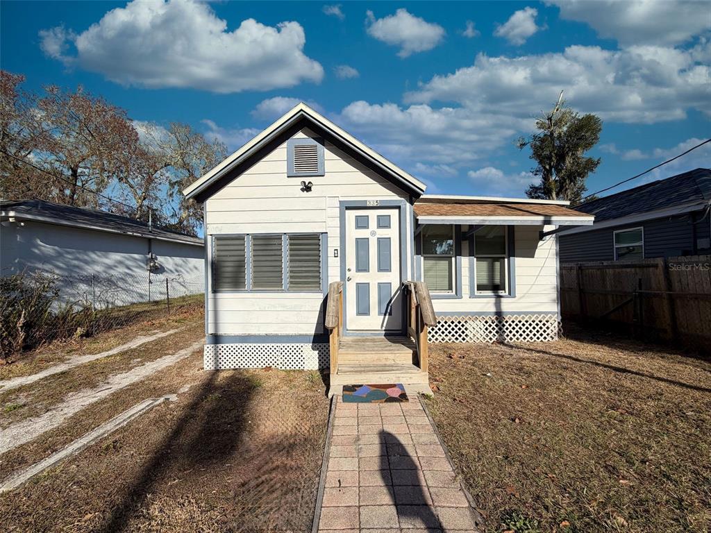 A single-story house with light siding, a gabled roof, and a chain-link fence — 335 MAPLE STREET, DAYTONA BEACH, FL