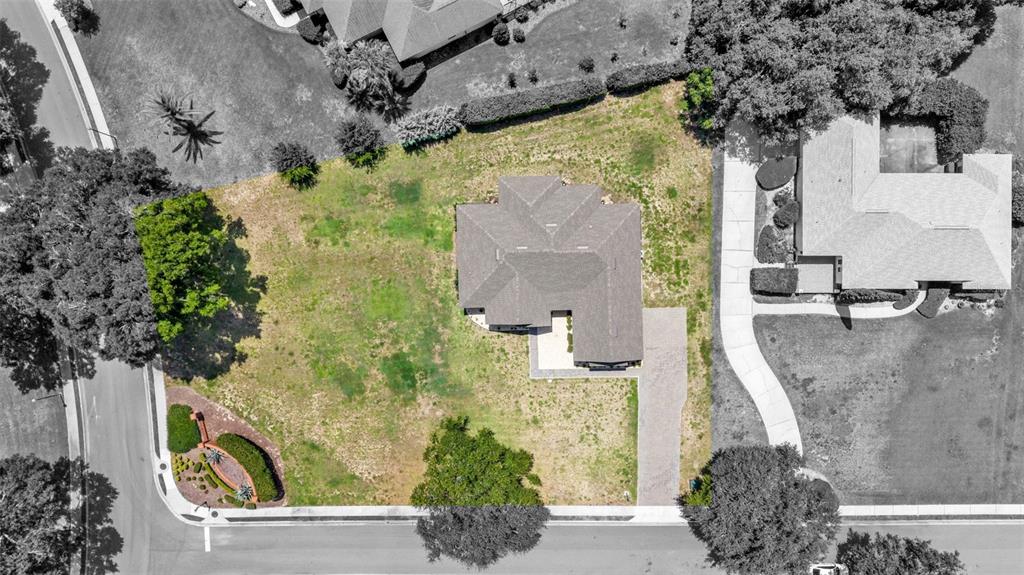 An aerial view shows a single-story house situated on a large, grassy corner lot — 5701 CRESTVIEW DRIVE, LADY LAKE, FL