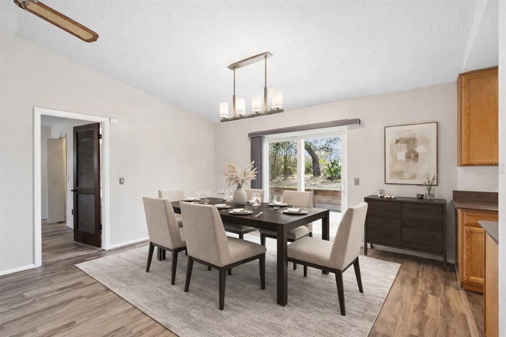A dining room features a dark wood table, six upholstered chairs, and a modern light fixture — 501 ANTOINETTE STREET, DELTONA, FL