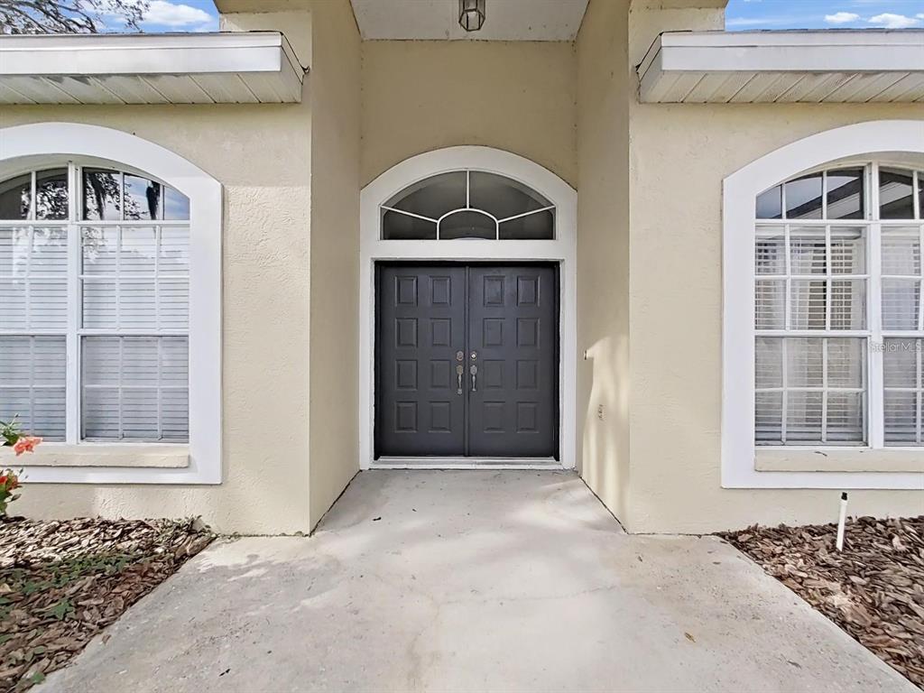 A front entrance features a dark double door with an arched transom window — 3307 KILMER PLACE, PLANT CITY, FL
