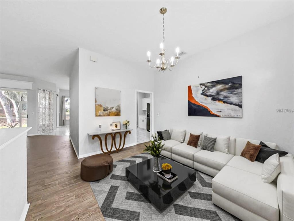 A living room features a white sectional sofa, a black coffee table, and a chandelier — 3307 KILMER PLACE, PLANT CITY, FL