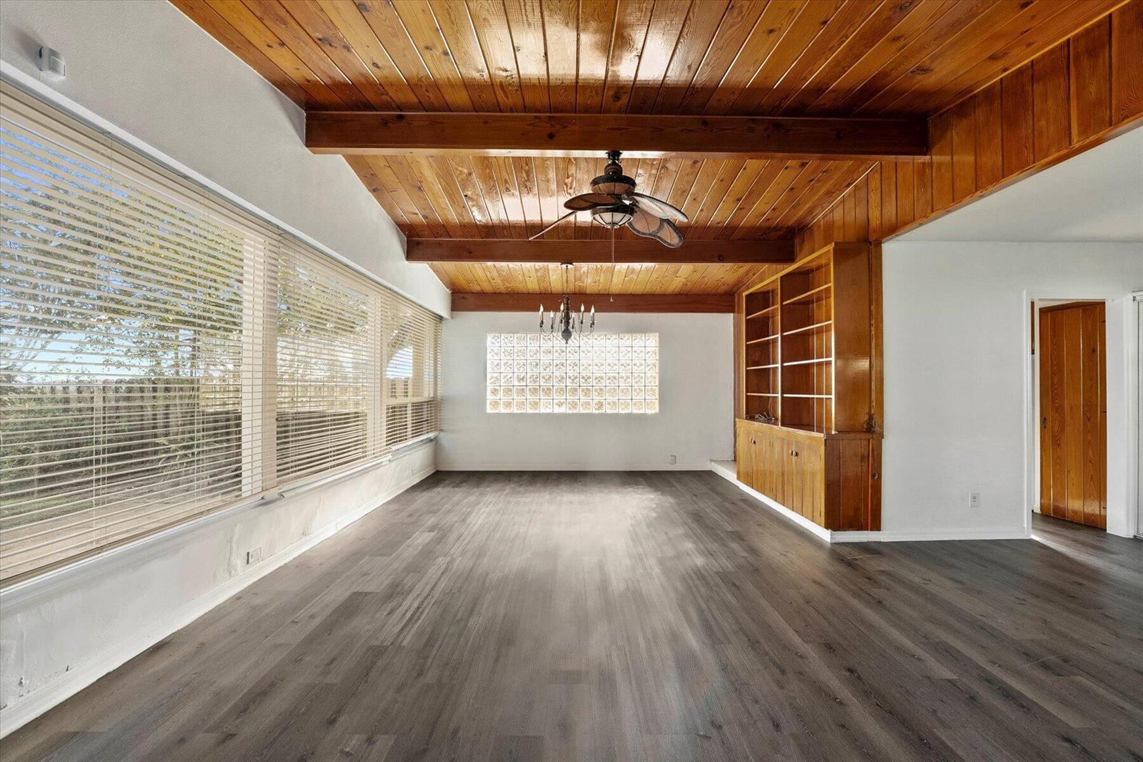 An empty room features a wood-paneled vaulted ceiling with beams, glass block windows, and flooring — 101 S Colorado Avenue, Stuart FL 34994, STUART, FL