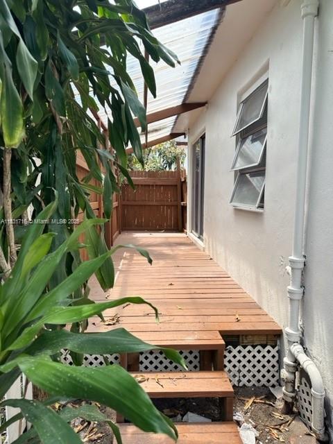 A wooden deck with steps leads along the side of a house with louvered windows — 42 SE 10th Ter, Dania Beach FL 33004, DANIA BEACH, FL