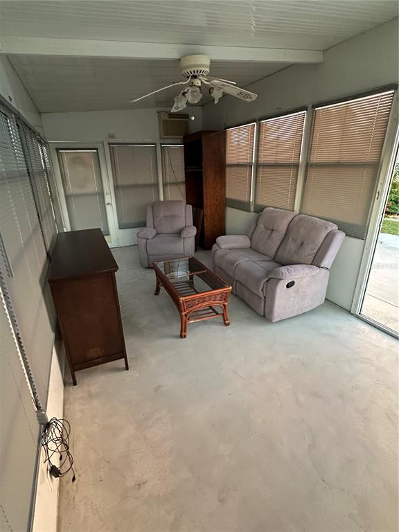A sunroom features a light-colored floor, a ceiling fan, a loveseat, and a recliner — 46900 BERMONT ROAD UNIT 310, PUNTA GORDA, FL
