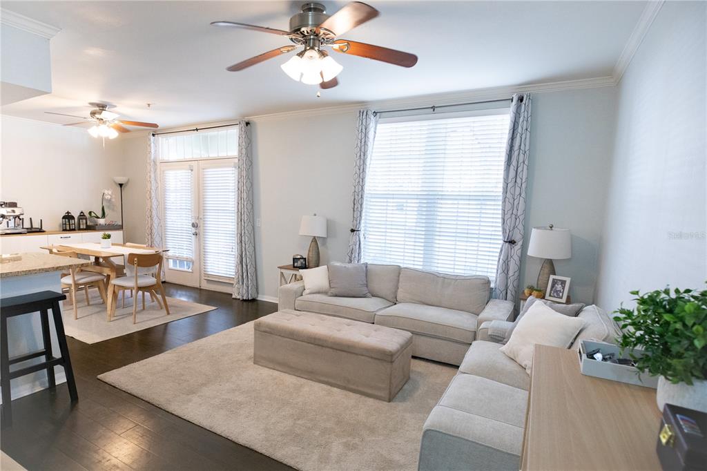 A living room and dining area feature hardwood floors, neutral furniture, and ceiling fans — 1020 SIENA PARK BOULEVARD W UNIT # 103, CELEBRATION, FL