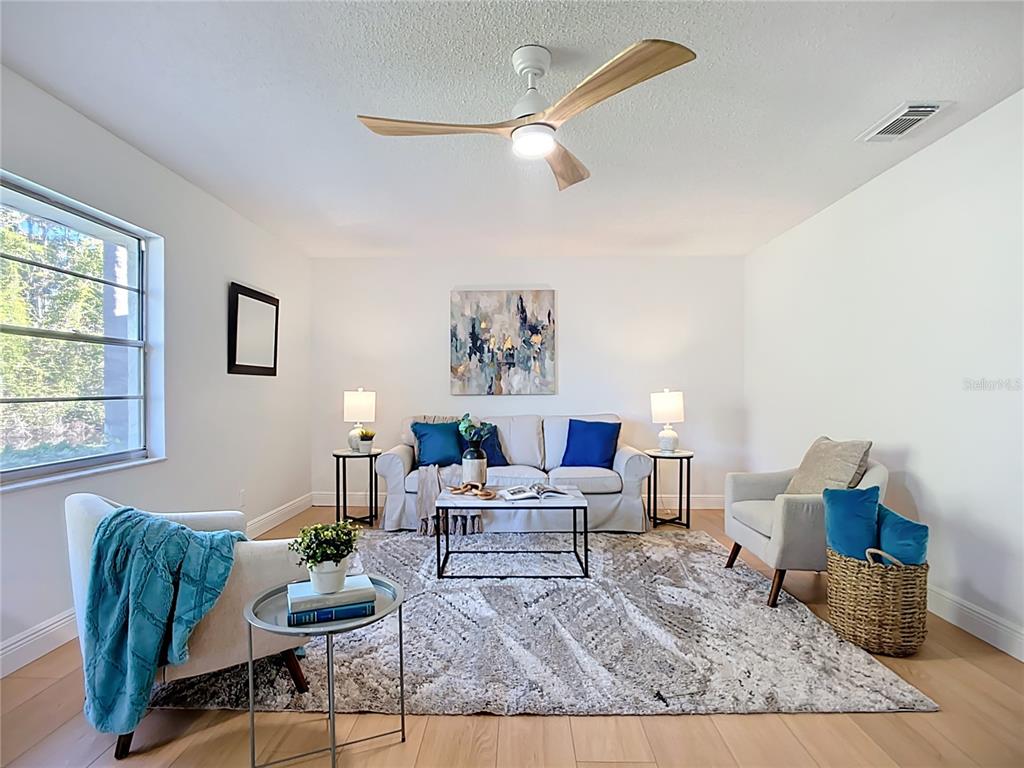 A living room features a sofa, two armchairs, a coffee table, and a ceiling fan — 2014 HAMPSTEAD CIRCLE, SUN CITY CENTER, FL