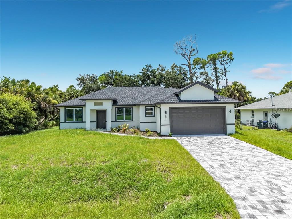 A single-story house with a white exterior, dark trim, and a paved driveway — 2607 SEAGULL LANE, NORTH PORT, FL