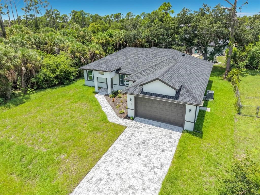 An aerial view of a single-story house with a paved driveway and a dark roof — 2607 SEAGULL LANE, NORTH PORT, FL