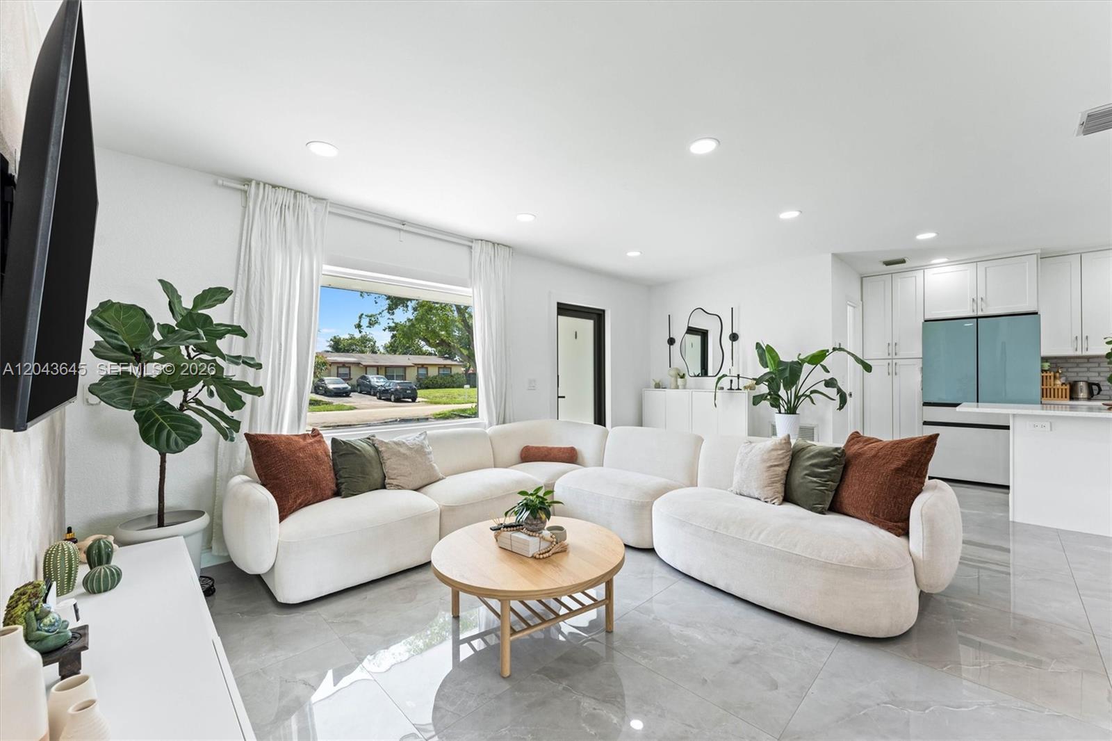 A living room features a large white sectional sofa, a round wooden table, and tile flooring — 1120 SW 7th Ave, Deerfield Beach FL 33441, DEERFIELD BEACH, FL