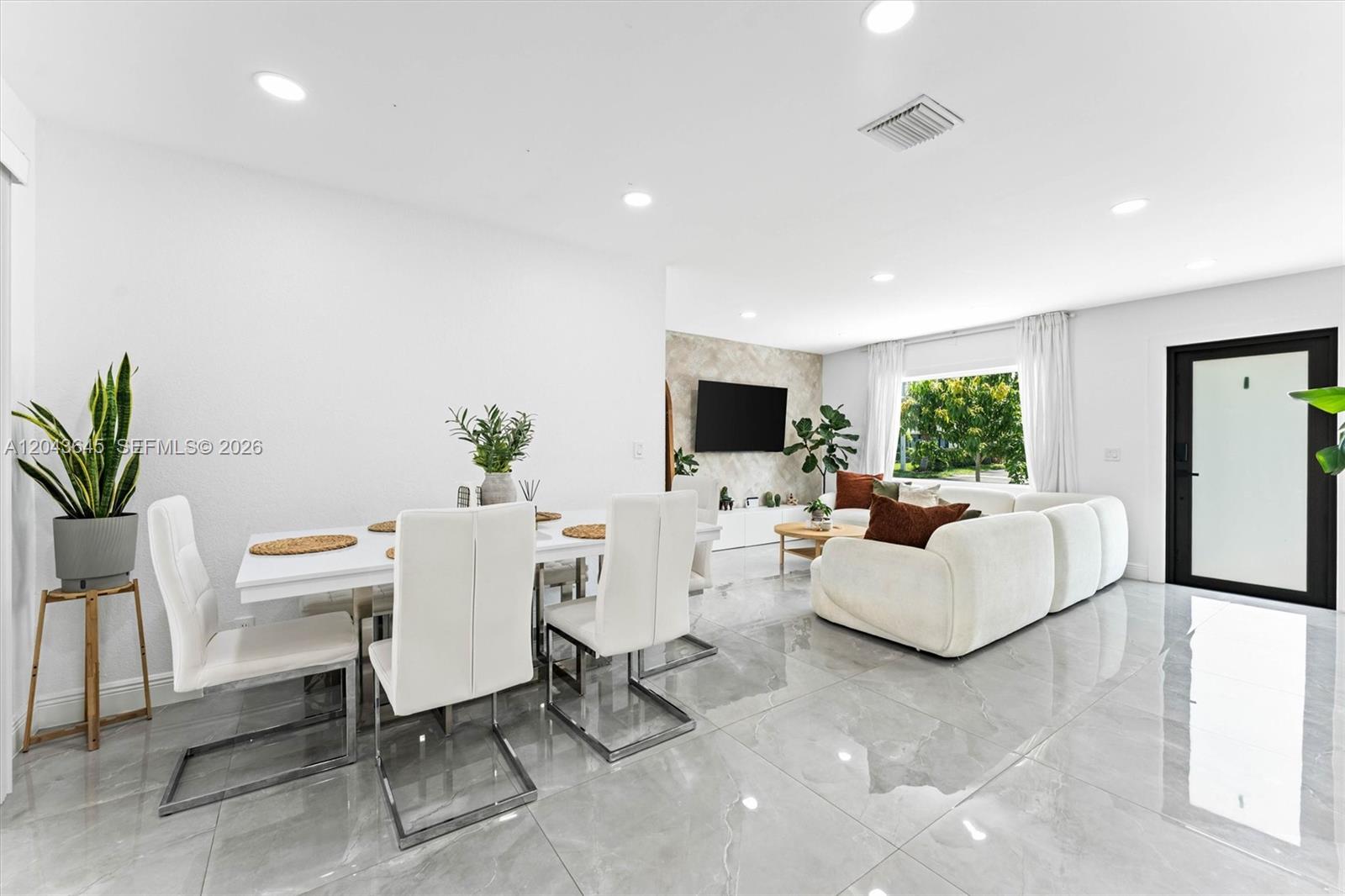 A bright, open-concept living and dining area features white furniture, gray tile floors, and recessed lighting — 1120 SW 7th Ave, Deerfield Beach FL 33441, DEERFIELD BEACH, FL
