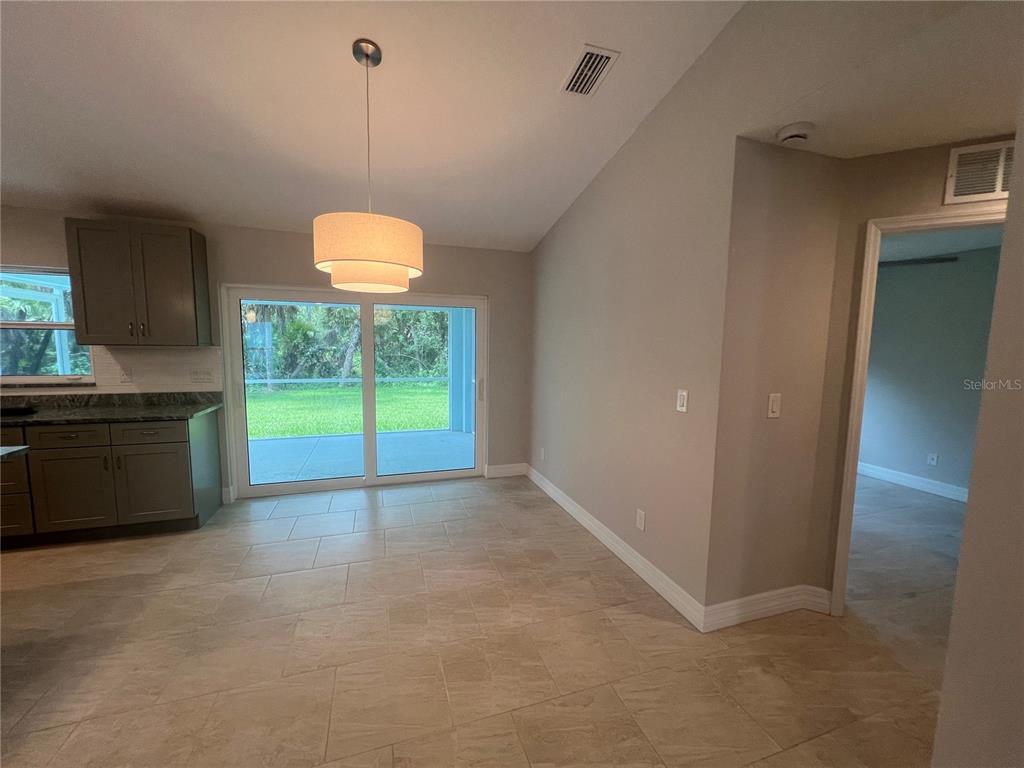 A dining area with tile flooring, a pendant light, and sliding glass doors to a patio — 2451 WALLER ROAD, NORTH PORT, FL