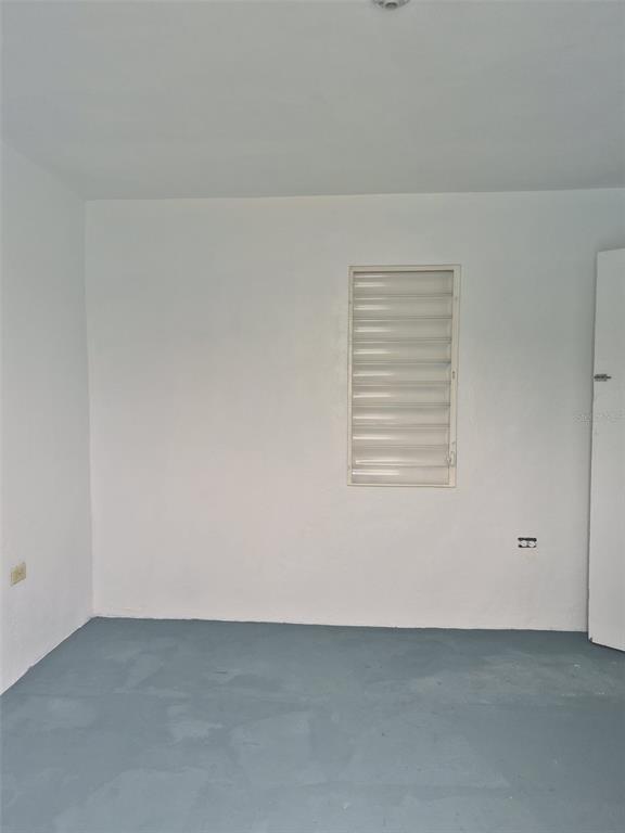 An empty room with white walls, a louvered window, and a painted blue floor — 1 BARRIO MORA, ISABELA, PR