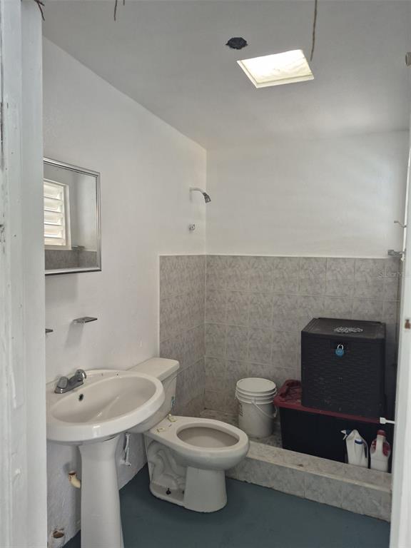 A bathroom features a pedestal sink, a toilet, and a shower area with tiled walls — 1 BARRIO MORA, ISABELA, PR