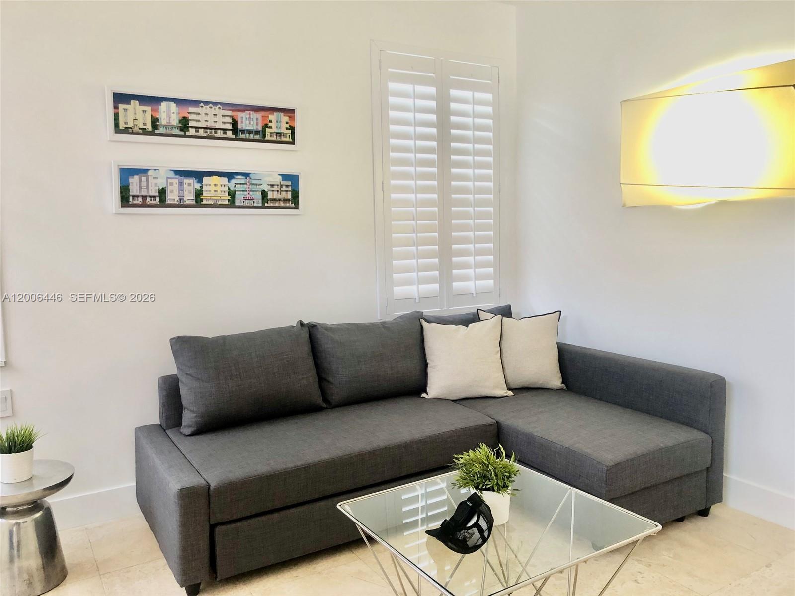 A living room features a gray sectional sofa, a glass coffee table, and wall art — 826 7th St # 3, Miami Beach FL 33139, MIAMI BEACH, FL