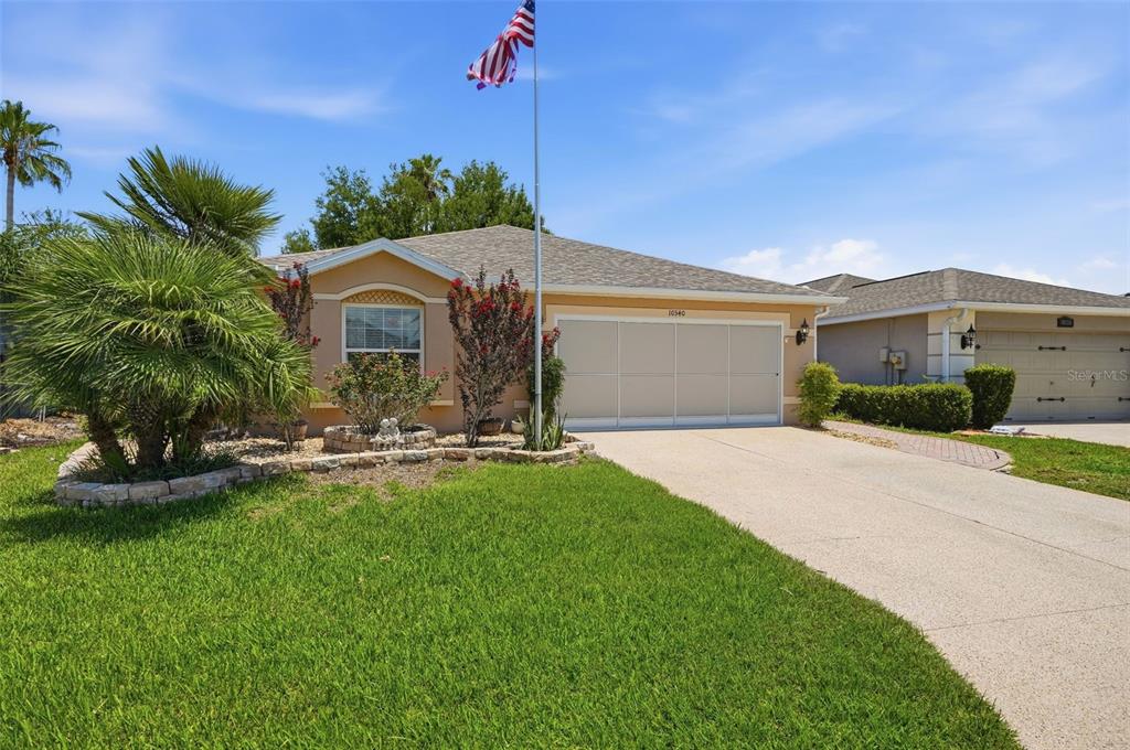 A single-story house with a beige exterior, a two-car garage, and a front yard — 10340 BUNCOMBE WAY, SAN ANTONIO, FL