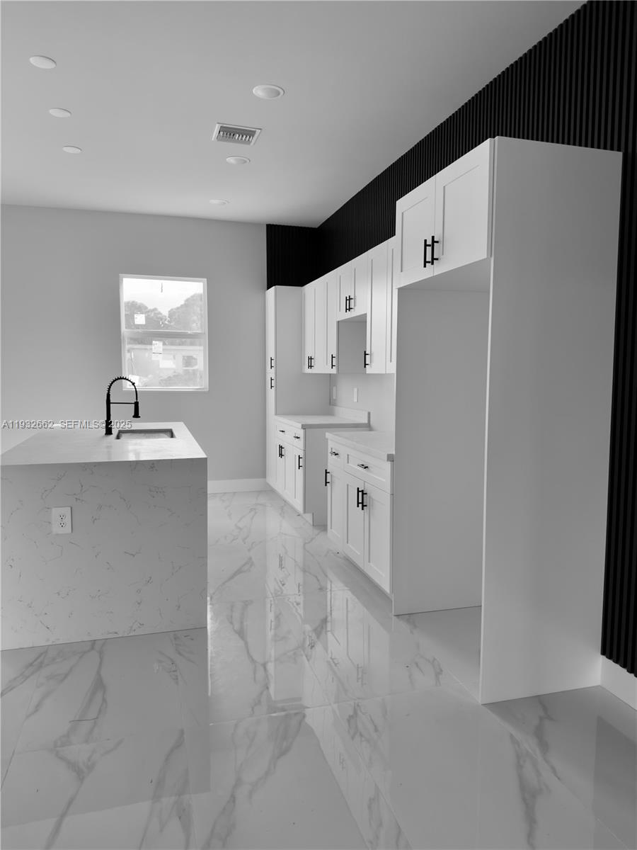A minimalist room features white walls, a double glass door, and polished marble-look tile flooring — 748 748 CHESTNUT ST E, Lehigh Acres FL 33974, LEHIGH ACRES, FL
