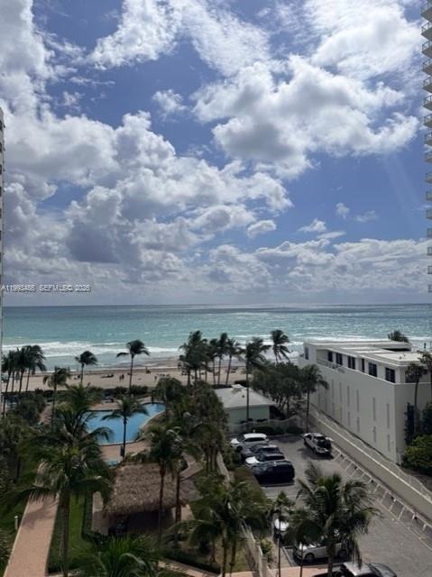 An elevated view of a beach, ocean, palm trees, a swimming pool, and a parking lot — 3901 S Ocean Dr # 7M, Hollywood FL 33019, HOLLYWOOD, FL