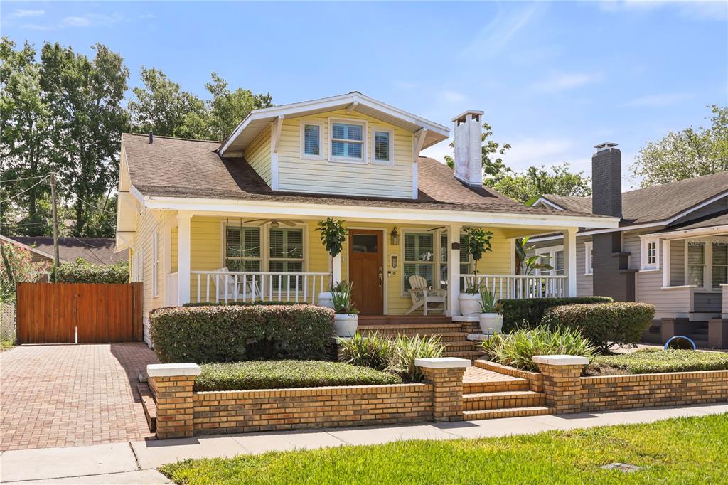 A yellow bungalow with a front porch, brick retaining wall, and a paved driveway — 343 BROADWAY AVENUE, ORLANDO, FL