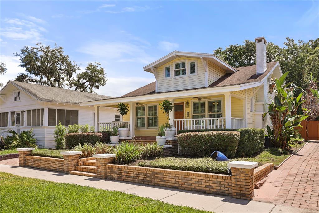 A yellow bungalow with a brick retaining wall and a covered front porch — 343 BROADWAY AVENUE, ORLANDO, FL