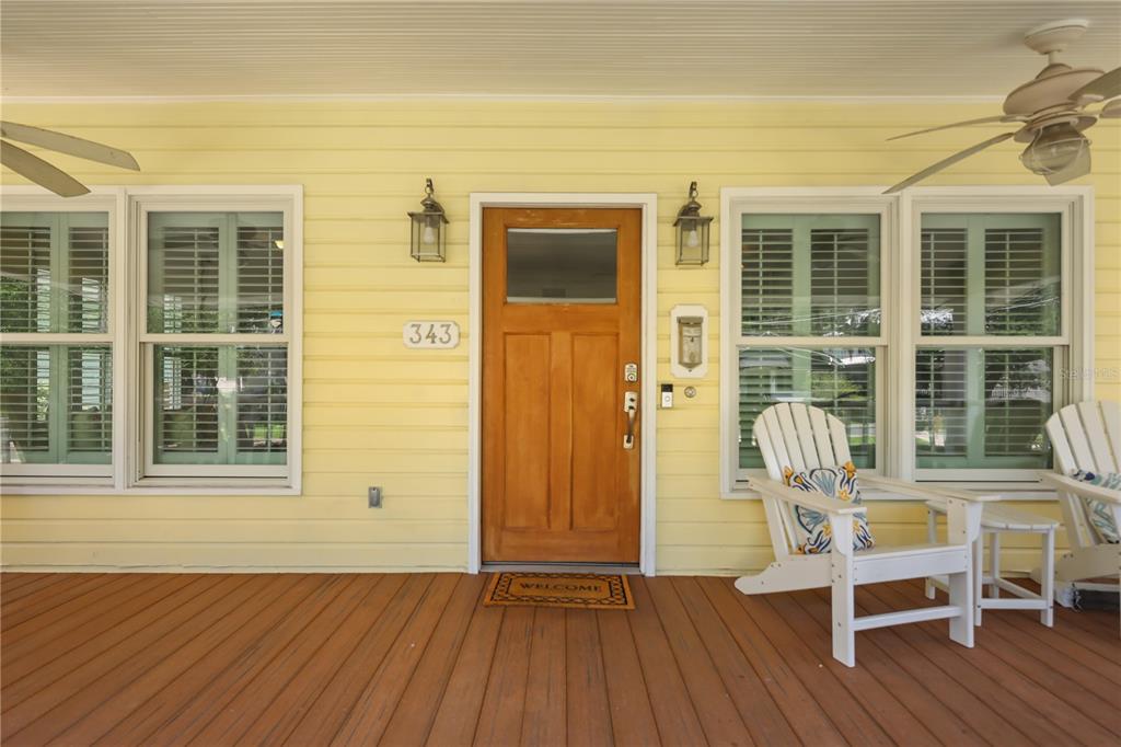 A yellow house exterior features a wooden front door, a porch, and two ceiling fans — 343 BROADWAY AVENUE, ORLANDO, FL