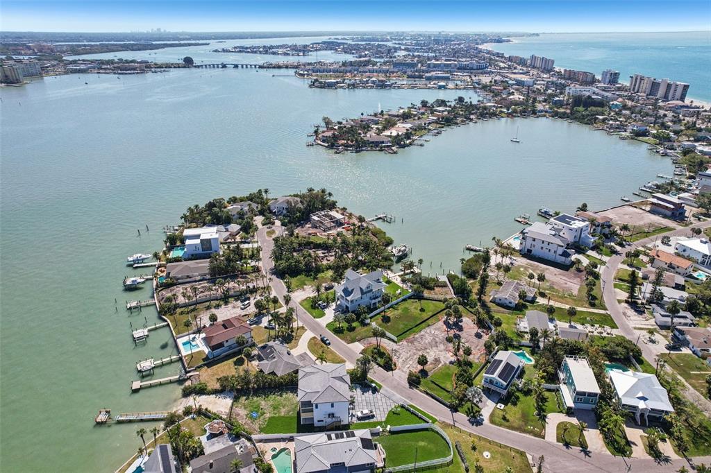 An aerial view shows waterfront homes along a coastal inlet with docks and green lawns — 15825 REDINGTON DRIVE, REDINGTON BEACH, FL