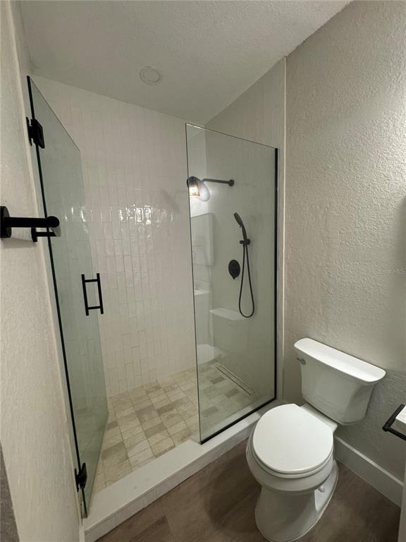 A bathroom features a glass-enclosed walk-in shower with white subway tiles and a white toilet — 5000 CULBREATH KEY WAY UNIT 8-122, TAMPA, FL