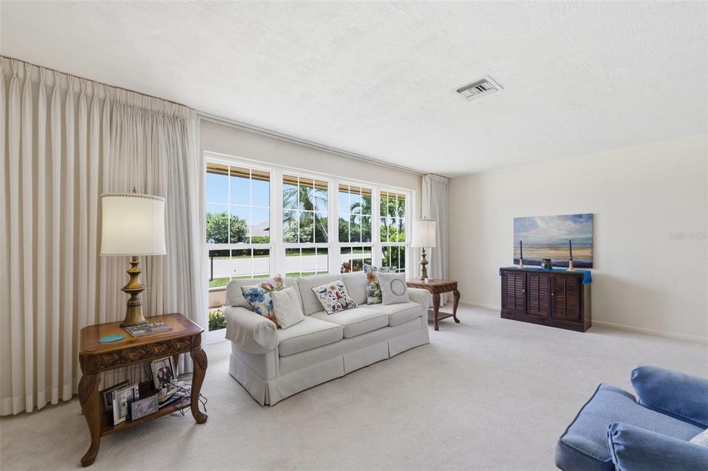 A living room features a white sofa, two side tables with lamps, and large windows — 1335 WHISKEY CREEK DRIVE, FORT MYERS, FL