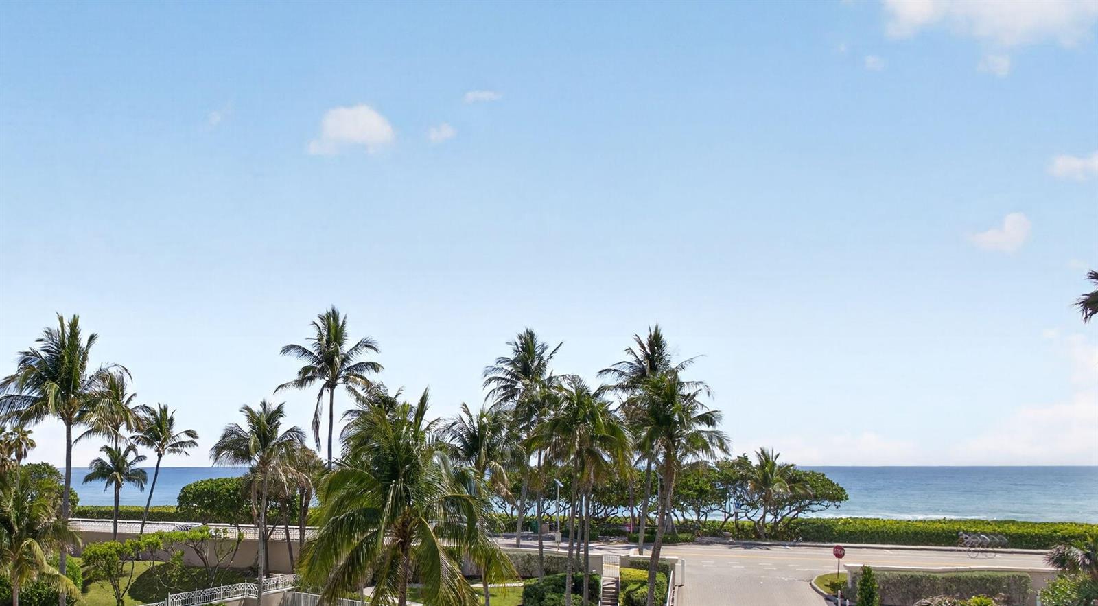 A view of palm trees, a coastal road, and the ocean under a blue sky — 1660 S Highway A1a (plus Deeded Sep. Guest Quarters) # 222, Jupiter FL 33477, JUPITER, FL