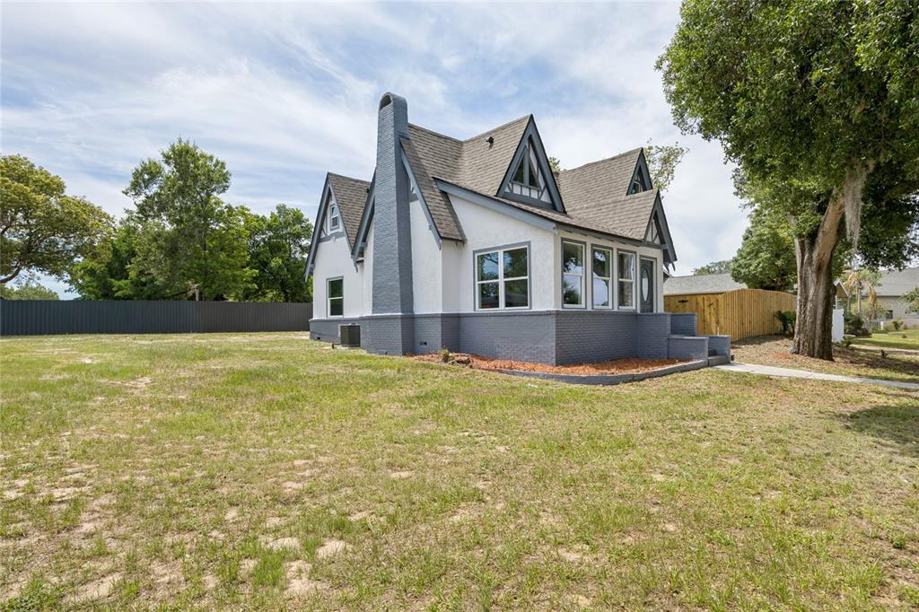 A two-story house with a white stucco and grey brick exterior features a prominent chimney — 1326 EAST AVENUE, CLERMONT, FL