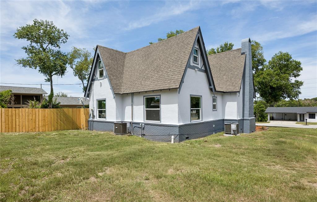 The exterior of a white and gray house with a steep roof and brick chimney — 1326 EAST AVENUE, CLERMONT, FL