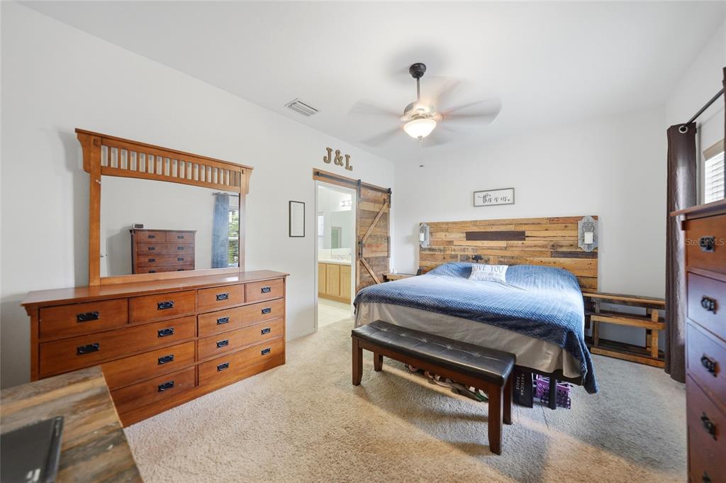 A bedroom features a wooden headboard, a large dresser with a mirror, and a ceiling fan — 4481 BALSEY STREET, NORTH PORT, FL