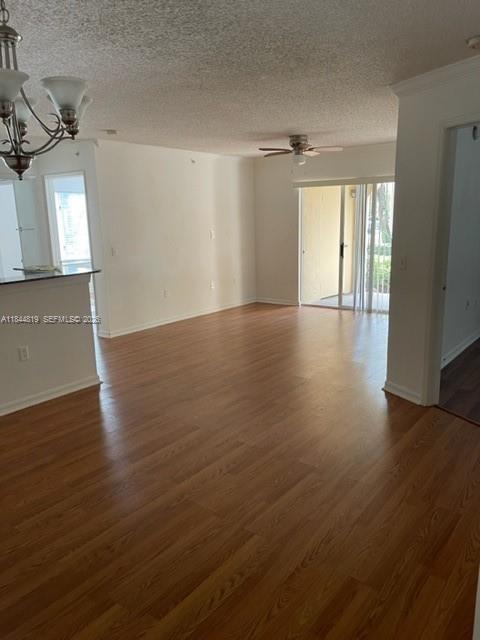 An open-concept living area features wood-look flooring, a ceiling fan, and a sliding glass door — 2494 Centergate Dr # 102, Miramar FL 33025, MIRAMAR, FL