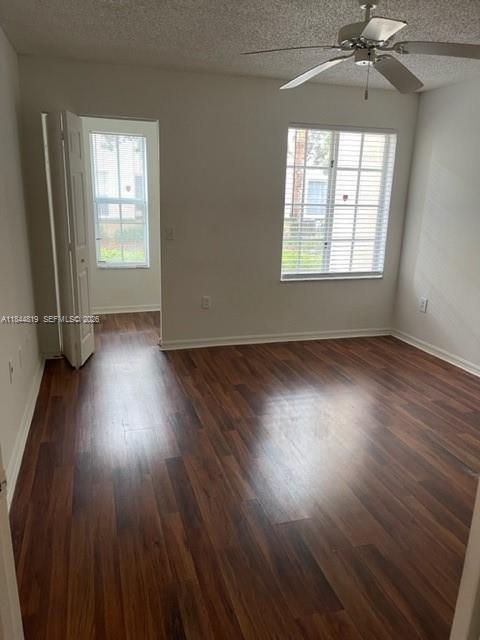 An empty bedroom features dark wood-look flooring, a ceiling fan, and a window with blinds — 2494 Centergate Dr # 102, Miramar FL 33025, MIRAMAR, FL