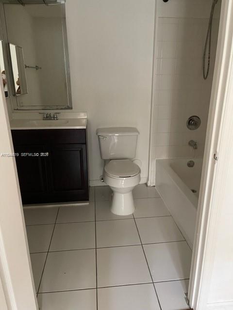 A bathroom featuring a dark wood vanity, a white toilet, and a shower-tub combination — 2494 Centergate Dr # 102, Miramar FL 33025, MIRAMAR, FL