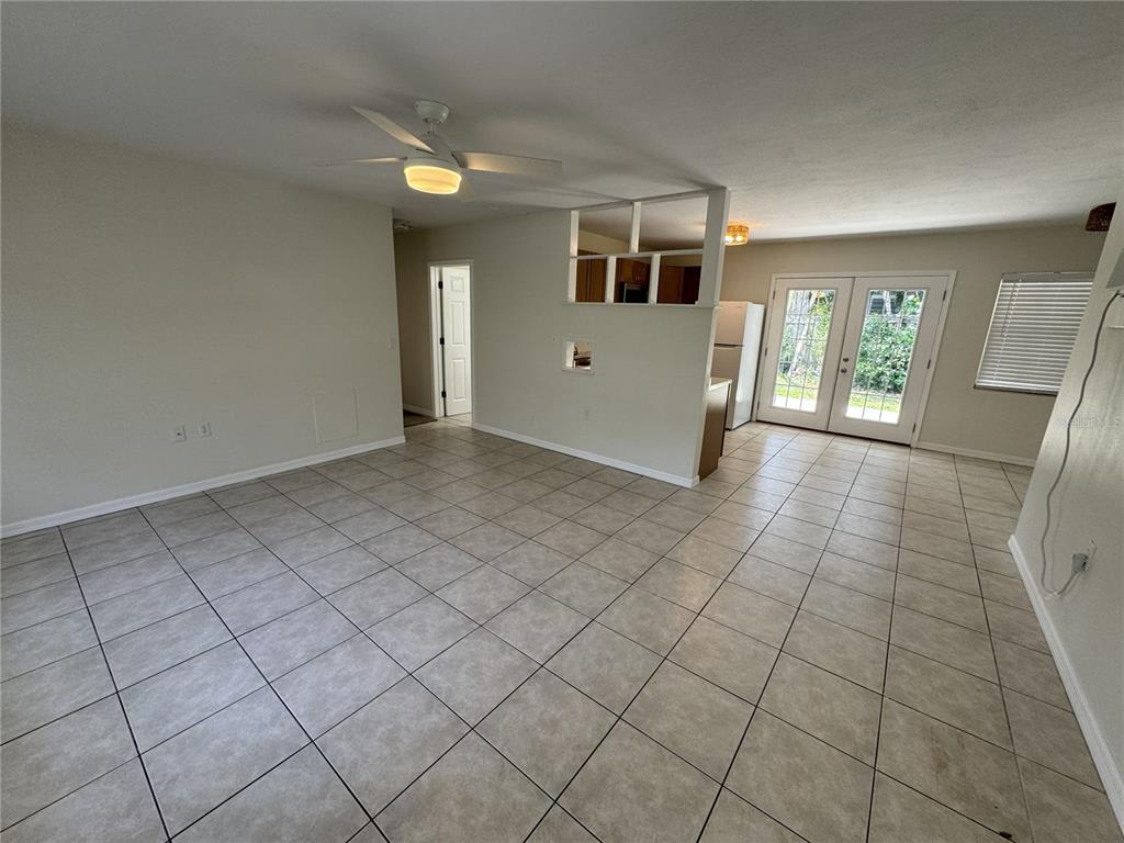 An open-concept living and dining area features light-colored tile flooring and a ceiling fan — 516 LAUREL ROAD W, NOKOMIS, FL