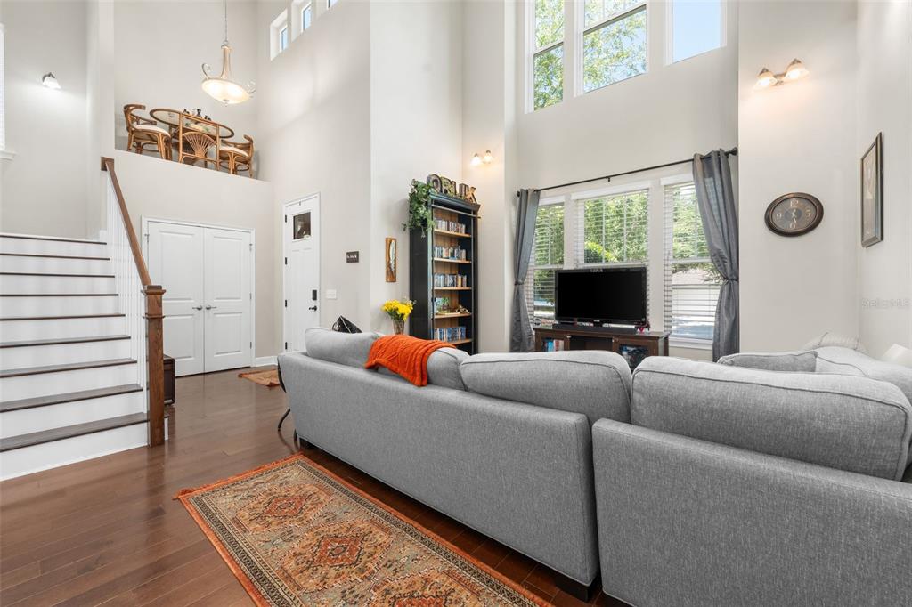 An entryway features hardwood floors, a white front door, double closet doors, and stairs — 8317 SW 78TH LANE, GAINESVILLE, FL