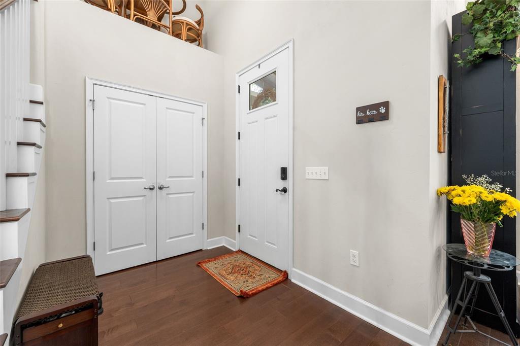 A living room features high ceilings, hardwood floors, a grey sofa, and a large bookshelf — 8317 SW 78TH LANE, GAINESVILLE, FL