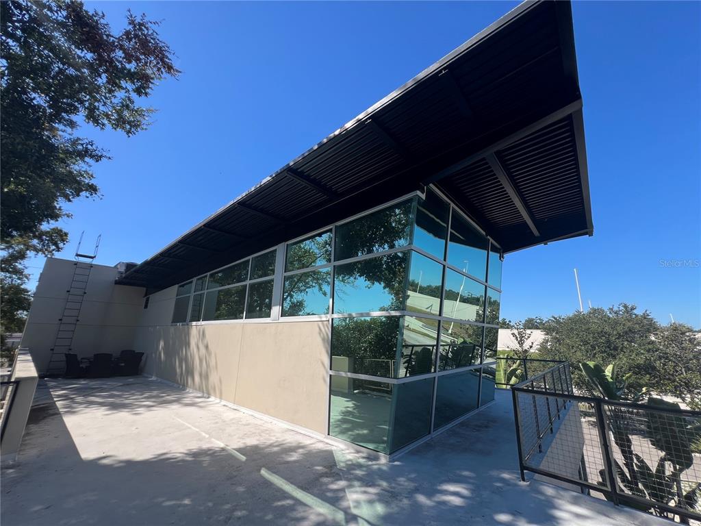A modern building exterior features a flat roof, large glass windows, and a concrete deck — 4007 N TALIAFERRO AVENUE UNIT B-C-D, TAMPA, FL