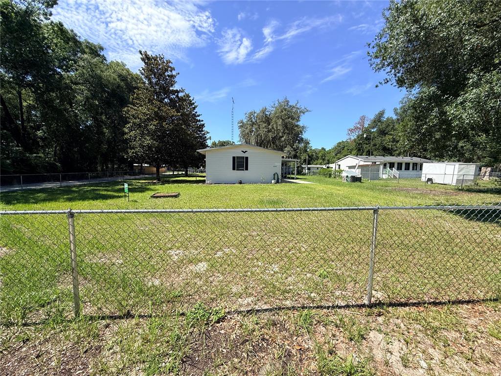 A white house with a garage and a covered porch sits on a grassy lot — 2828 NE 147TH TERRACE, SILVER SPRINGS, FL